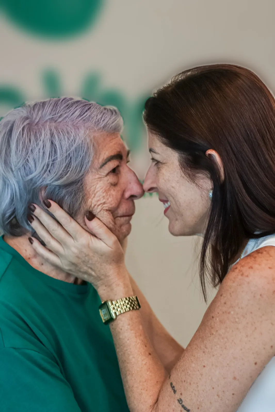Suzana e uma mulher da família encostam o nariz, sorrindo